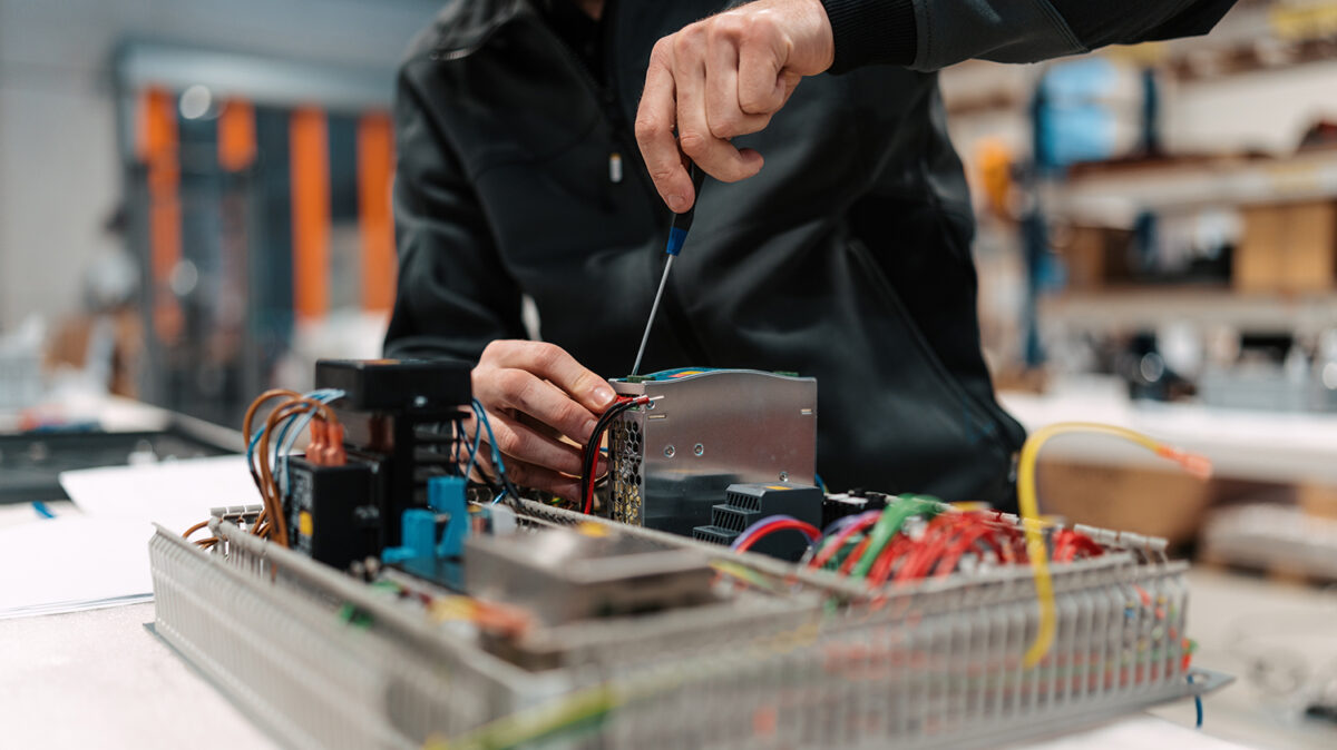 Person arbeitet an Elektroinstallation