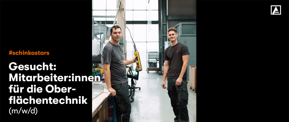 2 Männer stehen in Produktion und lächeln