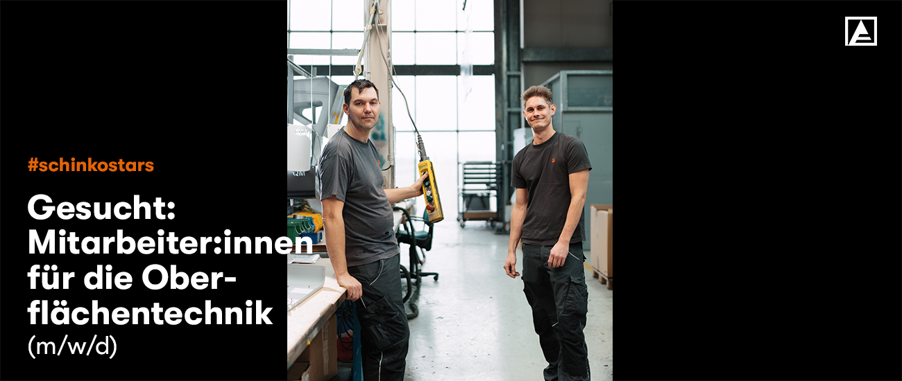 2 Männer stehen in Produktion und lächeln